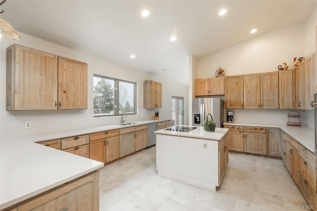 kitchen with a center island, a sink, vaulted ceiling, light countertops, and appliances with stainless steel finishes