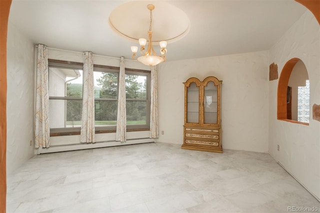 unfurnished room featuring a baseboard radiator and a notable chandelier