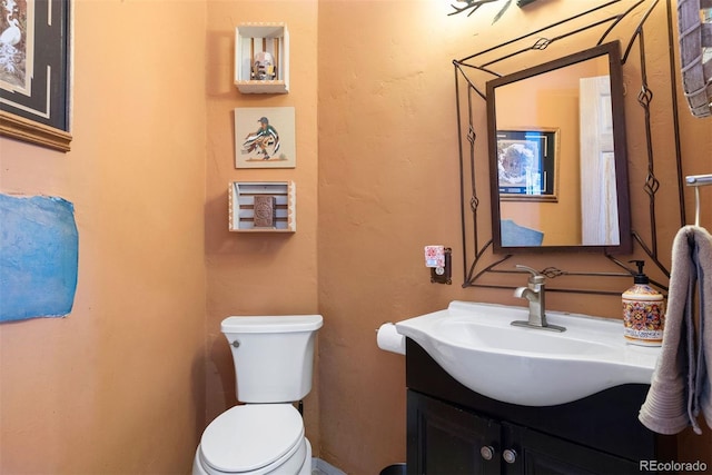 bathroom featuring toilet and vanity
