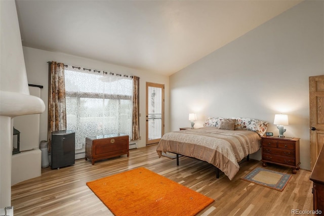bedroom featuring light wood finished floors, lofted ceiling, a baseboard radiator, and access to outside