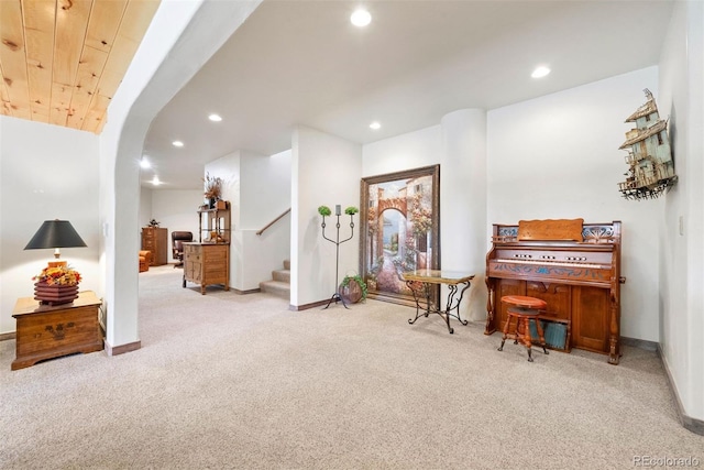 sitting room featuring arched walkways, stairway, recessed lighting, and carpet floors
