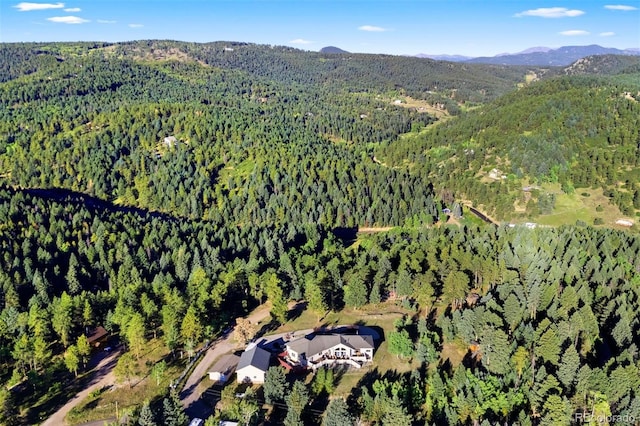 drone / aerial view featuring a forest view and a mountain view