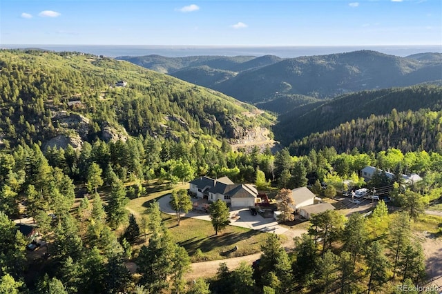 drone / aerial view featuring a mountain view and a view of trees