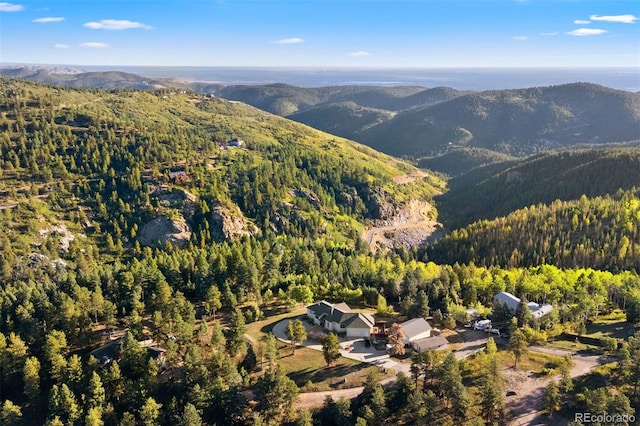 aerial view featuring a wooded view and a mountain view