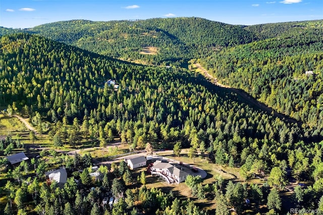 birds eye view of property with a mountain view and a wooded view