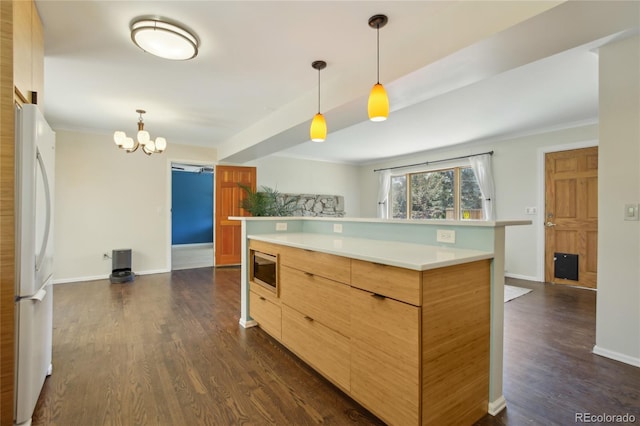 kitchen featuring freestanding refrigerator, stainless steel microwave, light countertops, dark wood-style floors, and a kitchen island