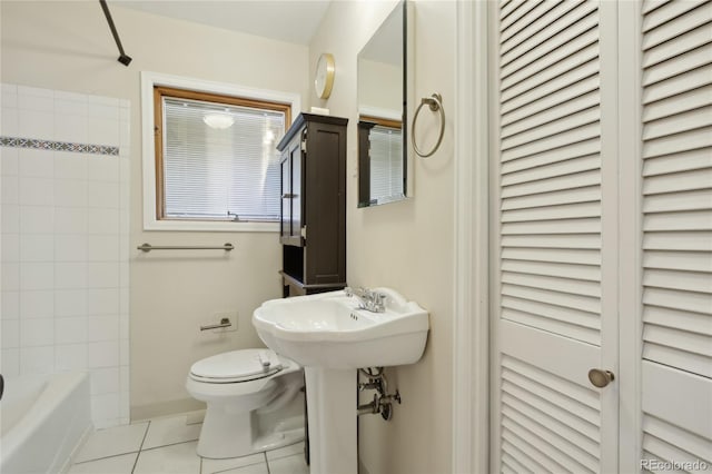 full bathroom with a closet, toilet, tile patterned floors, and shower / tub combination