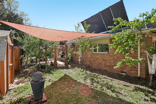view of front of home featuring brick siding, a patio area, and fence