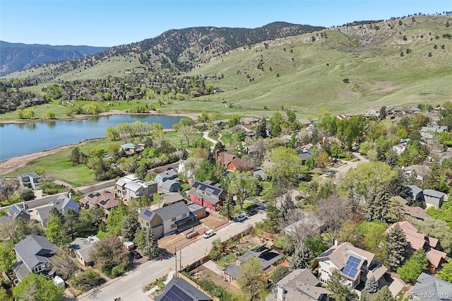 aerial view of property's location featuring a water and mountain view and nearby suburban area