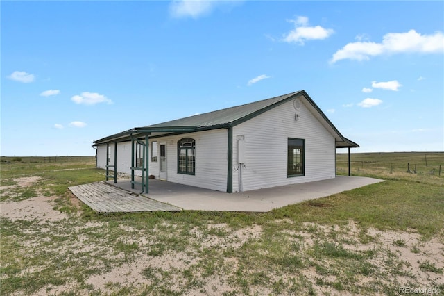 exterior space with a yard, a rural view, and a patio area