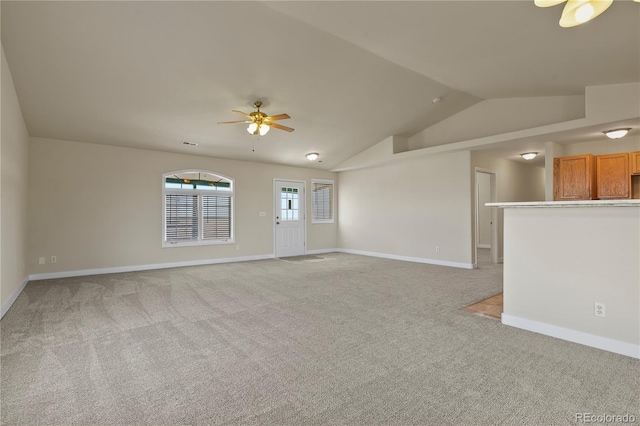 unfurnished living room with vaulted ceiling, light carpet, and ceiling fan