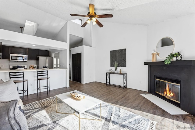 6447 Jonathan Ct, Colorado Springs, CO 80918 - living room with dark wood-type flooring, high vaulted ceiling, a ceiling fan, and a fireplace with flush hearth
