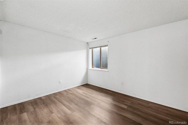 6447 Jonathan Ct, Colorado Springs, CO 80918 - spare room featuring visible vents, wood finished floors, and a textured ceiling