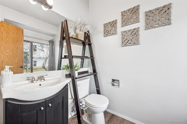 6447 Jonathan Ct, Colorado Springs, CO 80918 - half bathroom with toilet, baseboards, vanity, and wood finished floors