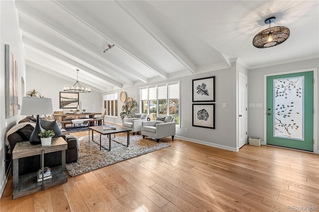 living room with a notable chandelier, vaulted ceiling with beams, and hardwood / wood-style floors