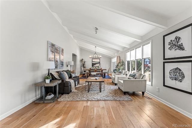 living room featuring hardwood / wood-style floors, vaulted ceiling with beams, and a chandelier