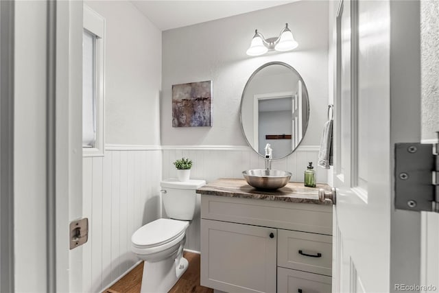 bathroom with toilet, vanity, and hardwood / wood-style flooring