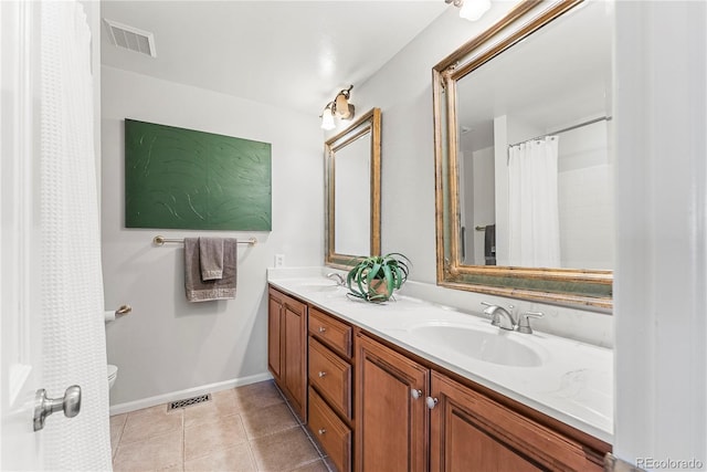 bathroom with toilet, tile patterned flooring, and vanity