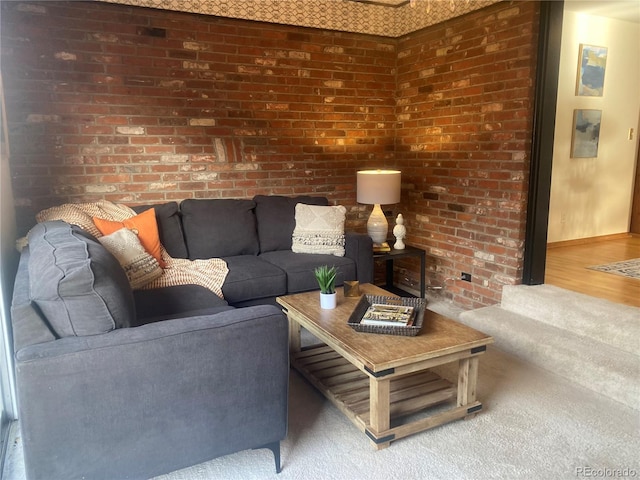 living room featuring hardwood / wood-style flooring and brick wall