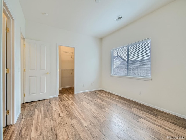 14700 E 104th Ave Unit 2605, Commerce City, CO 80022 - unfurnished bedroom with a spacious closet, light wood-style flooring, baseboards, and a closet