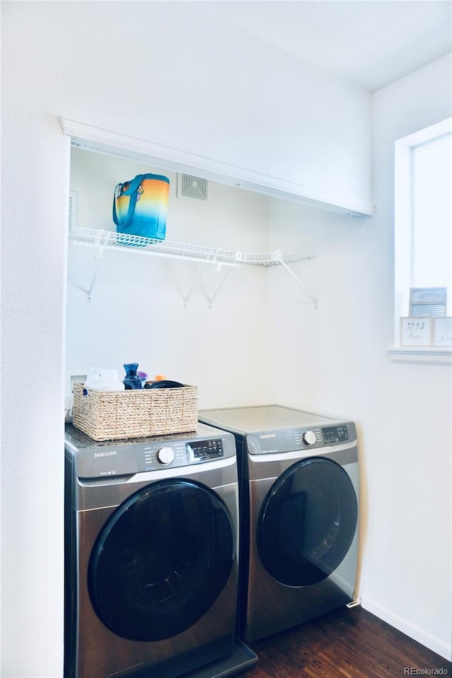 14700 E 104th Ave Unit 2605, Commerce City, CO 80022 - washroom featuring washer and clothes dryer, dark wood-type flooring, and baseboards