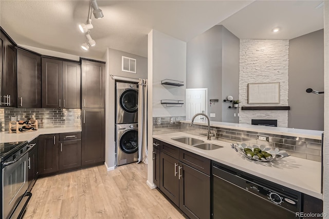 kitchen featuring a sink, stacked washer / drying machine, black dishwasher, electric range oven, and dark brown cabinets