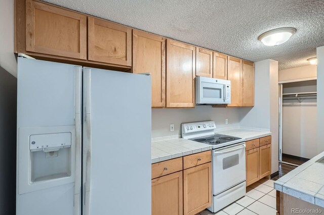 2225 Buchtel Blvd Unit 1003, Denver, CO 80210 - kitchen with tile countertops, a textured ceiling, light brown cabinets, and white appliances