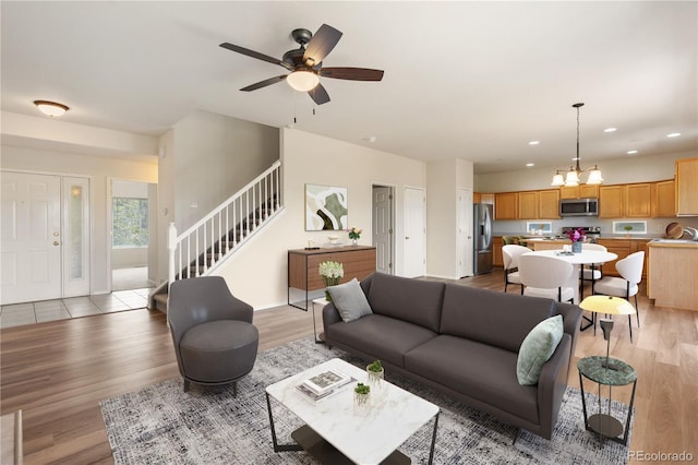 4839 Spotted Horse Dr, Colorado Springs, CO 80923 - living room with stairs, light wood-style flooring, recessed lighting, ceiling fan, and a chandelier