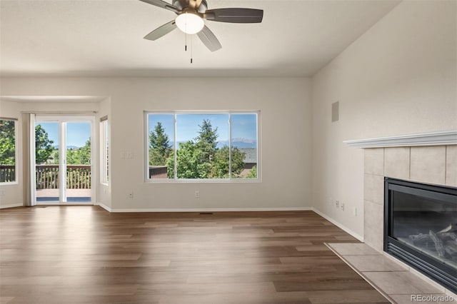 4839 Spotted Horse Dr, Colorado Springs, CO 80923 - unfurnished living room with dark wood-type flooring, a fireplace, and a ceiling fan