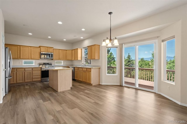 4839 Spotted Horse Dr, Colorado Springs, CO 80923 - kitchen with stainless steel appliances, light countertops, a center island, wood finished floors, and recessed lighting