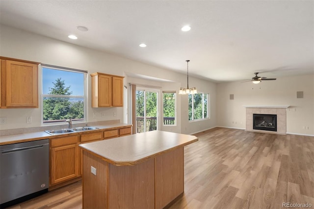 4839 Spotted Horse Dr, Colorado Springs, CO 80923 - kitchen with stainless steel dishwasher, light countertops, a ceiling fan, a center island, and a fireplace
