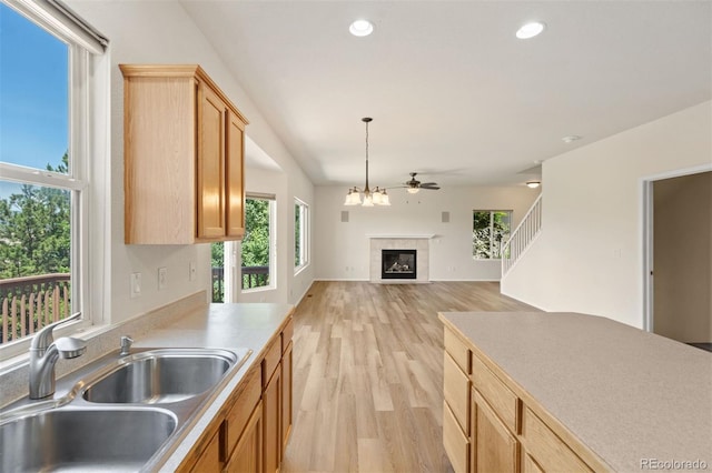 4839 Spotted Horse Dr, Colorado Springs, CO 80923 - kitchen with a glass covered fireplace, light wood-style floors, pendant lighting, light countertops, and recessed lighting