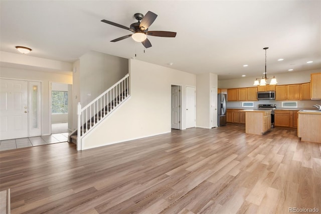 4839 Spotted Horse Dr, Colorado Springs, CO 80923 - unfurnished living room featuring recessed lighting, stairs, light wood-type flooring, a chandelier, and a ceiling fan