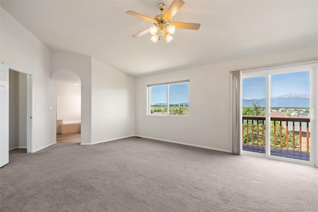 4839 Spotted Horse Dr, Colorado Springs, CO 80923 - spare room featuring vaulted ceiling, carpet floors, arched walkways, ceiling fan, and a mountain view