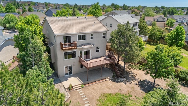 4839 Spotted Horse Dr, Colorado Springs, CO 80923 - rear view of property featuring stairs, a residential view, a balcony, stucco siding, and a wooden deck