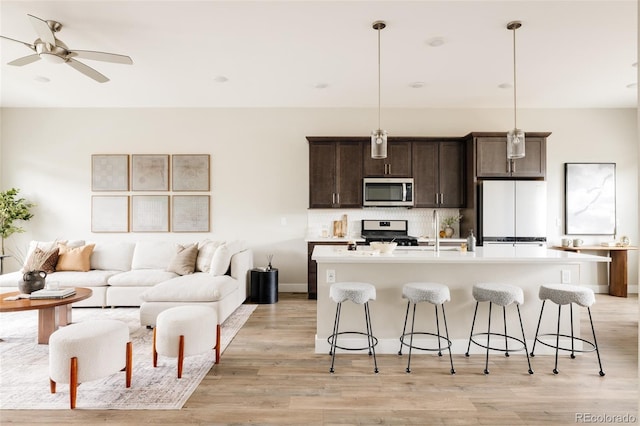 6307 Dayton Ct, Denver, CO 80238 - kitchen with freestanding refrigerator, stove, stainless steel microwave, and a breakfast bar