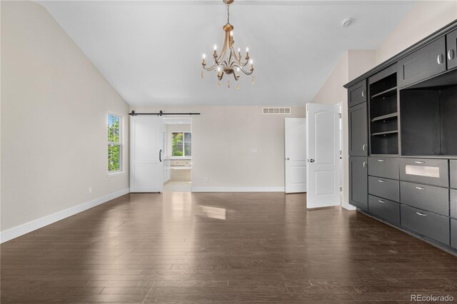 23870 E Dorado Pl, Aurora, CO 80016 - unfurnished living room with vaulted ceiling, a chandelier, dark wood finished floors, baseboards, and a barn door