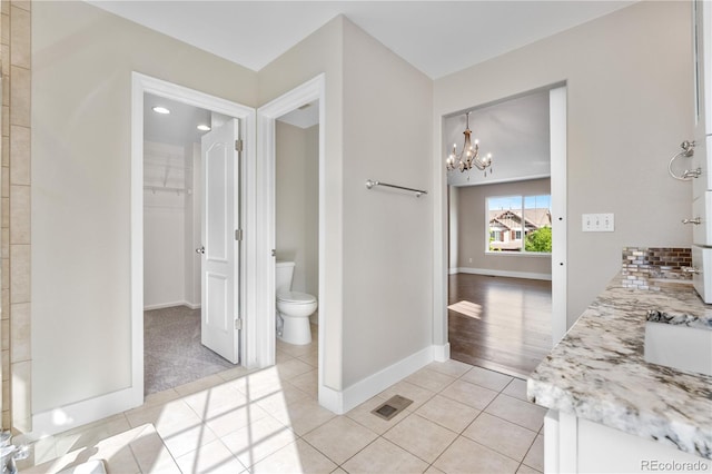 23870 E Dorado Pl, Aurora, CO 80016 - bathroom with tile patterned floors, a chandelier, toilet, baseboards, and vanity