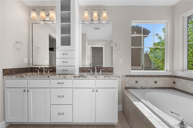 23870 E Dorado Pl, Aurora, CO 80016 - full bathroom with a relaxing tiled tub, double vanity, and decorative backsplash