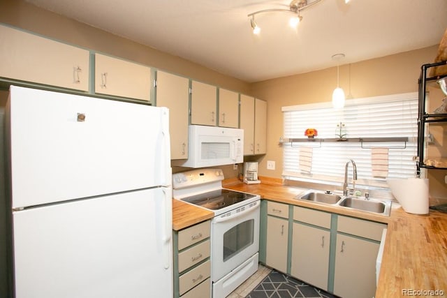 kitchen featuring white appliances, butcher block countertops, pendant lighting, and a sink