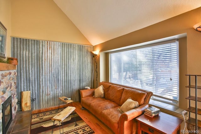 living room featuring a fireplace, vaulted ceiling, and tile patterned floors