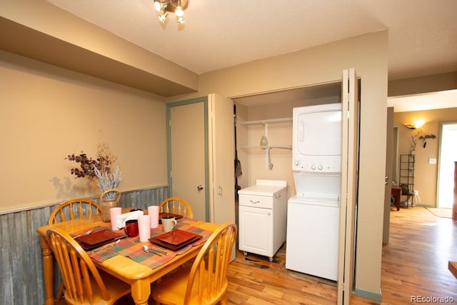 dining room with light wood finished floors and stacked washer / dryer