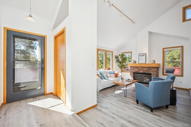 7350 Timber Trail Rd, Evergreen, CO 80439 - entryway with high vaulted ceiling, baseboards, rail lighting, light wood-type flooring, and plenty of natural light