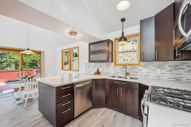 7350 Timber Trail Rd, Evergreen, CO 80439 - kitchen with appliances with stainless steel finishes, a sink, vaulted ceiling, a peninsula, and light countertops