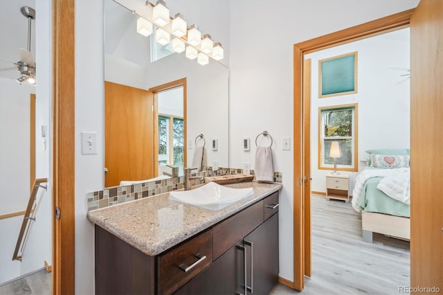 7350 Timber Trail Rd, Evergreen, CO 80439 - bathroom with ensuite bath, wood finished floors, vanity, decorative backsplash, and ceiling fan