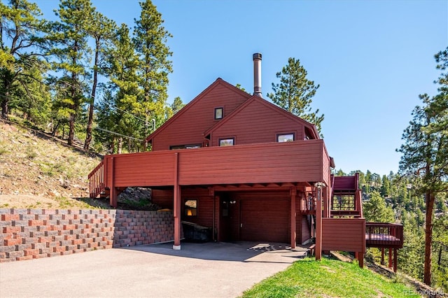7350 Timber Trail Rd, Evergreen, CO 80439 - view of front of property with driveway, an attached garage, a deck, and stairs