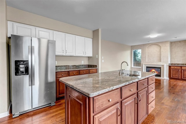12047 W Coal Mine Dr, Littleton, CO 80127 - kitchen with a sink, light stone counters, light wood finished floors, open floor plan, and stainless steel fridge