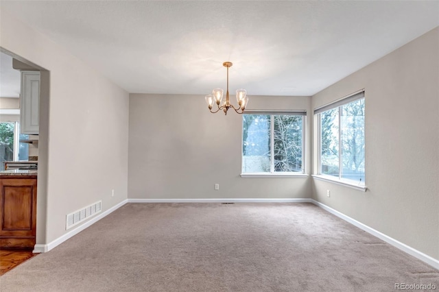 12047 W Coal Mine Dr, Littleton, CO 80127 - spare room featuring an inviting chandelier, visible vents, and carpet floors