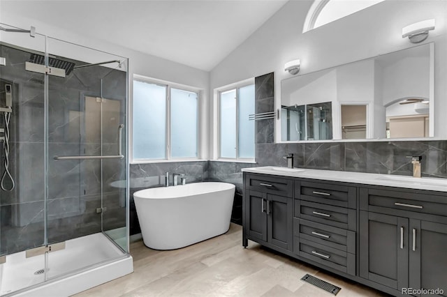 12047 W Coal Mine Dr, Littleton, CO 80127 - bathroom featuring a sink, lofted ceiling, a soaking tub, a shower stall, and double vanity