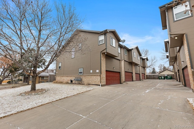 exterior space with a garage, a residential view, and concrete driveway